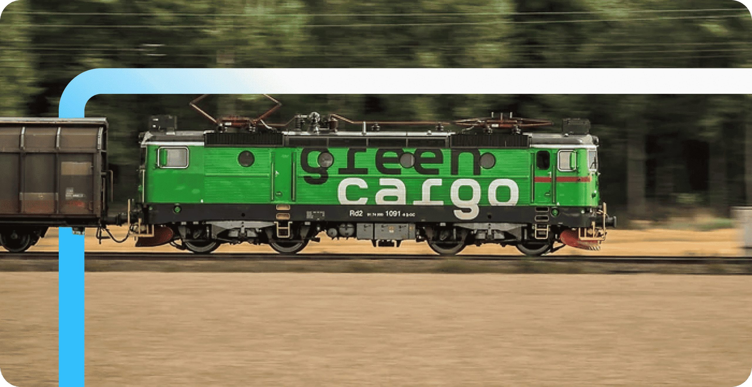 A green electric locomotive branded "green cargo" pulls a freight car along tracks with motion-blurred trees in the